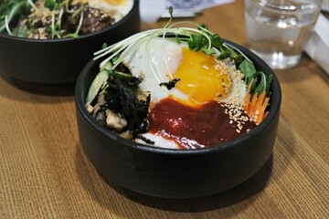 Bibimbap and rice with meat. Korean dish. Spicy food. Egg yolk on top of rice. Delicious and hearty Asian food