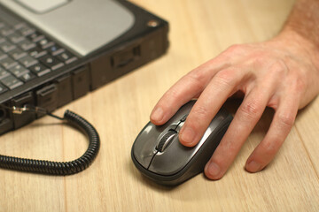 a person holds his hand on a computer mouse