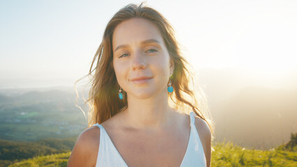 Portrait of the young caucasian woman outdoor at sunrise. Model looks into the camera