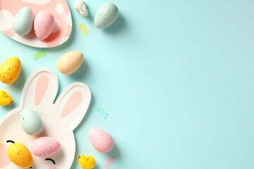 Happy Easter greeting card template. Easter table with colorful eggs and plates on blue background.