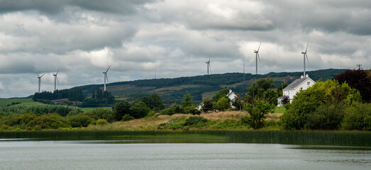 Ireland countryside with white cottage houses and windmills for wind alternative energy