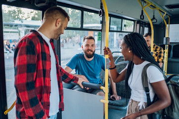 Multiracial friends talking while riding a bus in the city