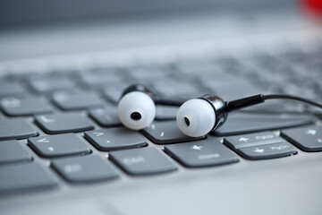 Obraz na płótnie Canvas Black earphone, close up photo, on the laptop keyboard