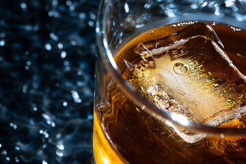 Alcohol beverage scotch in a glass with ice cube
