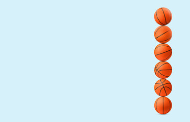 Stack of basketball balls on pale light blue background. Space for text