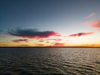 A sunset over the water with a pink cloud in the sky in LaPaz, Mexico 