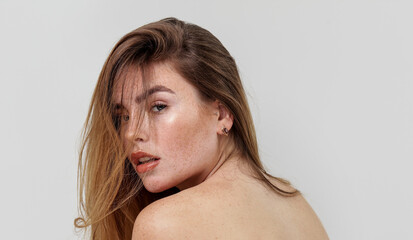 Beauty portrait of charming caucasian young woman with natural freckles on her face and shoulders