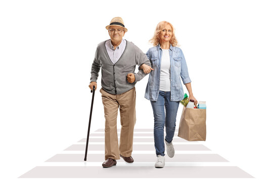 Woman Crossing Street And Helping Her Senior Father With Grocery Bags