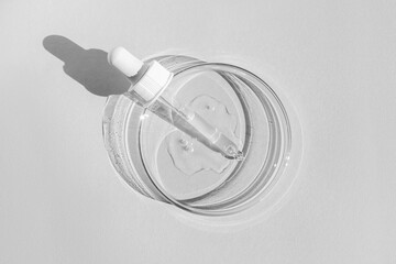 Petri dish. With transparent gel. The pipette lies. Cosmetic dispenser. On a white background.