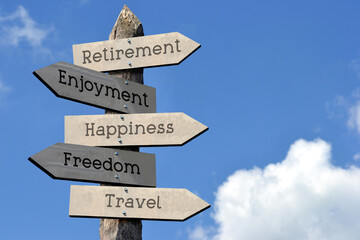 Retirement, enjoyment, happiness, freedom, travel - wooden signpost with five arrows, sky with clouds