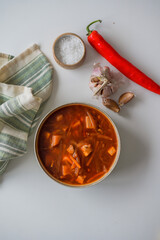 The traditional Ukrainian first course is red borsch. Hot borsch on the table with garlic, pepper and salt. Recipe for borscht made from vegetables