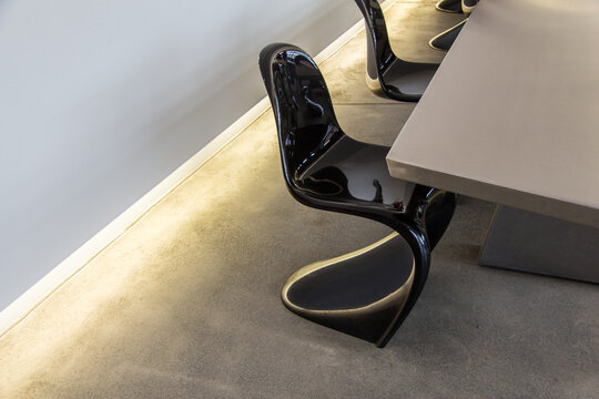 Black plastic Panton Chairs around a conference table.