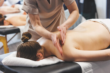 Professional massage therapist giving back massage for natural pretty woman. Natural beauty massage spa self care shot
