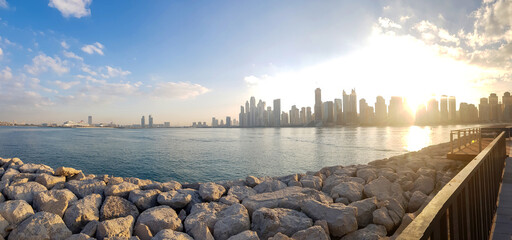 Fototapeta premium Panoramic view of Business Bay district with reflection in sea in morning. Aerial sky at highest buildings in central Dubai, United Arab Emirates