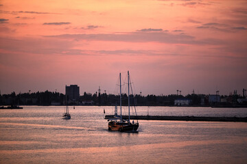 A wooden yacht in port during sunset