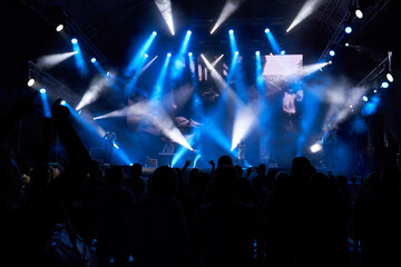 Colourful concert arena with a crowd silhouette against stage lights. silhouettes of the audience against the background of the concert stage