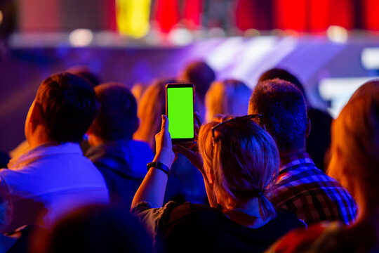 Filming a concert with his smartphone