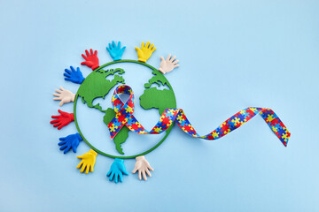 Hands and puzzle ribbon for World Autism Awareness Day.