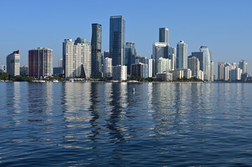 Fototapeta na wymiar Miami, Florida skyline reflected on calm Biscayne Bay in morning light on sunny clear day.