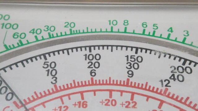 close-up of measuring voltage with a multimeter. close-up of the screen of a pointer multimeter with green and red numbers