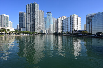 Fototapeta na wymiar Residential and office towers in downtown Miami, Florida reflected in calm water of Biscayne Bay on sunny clear morning.