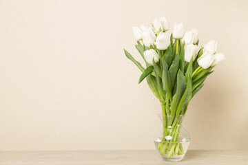 Tulip flowers in vase on wooden table