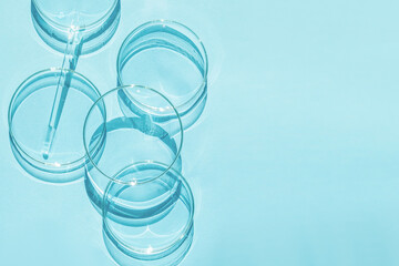 Petri dish. A set of Petri cups. A pipette, glass tube. On a blue blue background.