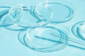 Petri dish. A set of Petri cups. A pipette, glass tube. On a blue blue background.