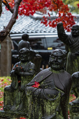 日本　京都府京都市の嵐山羅漢にある雨に濡れた羅漢像と紅葉