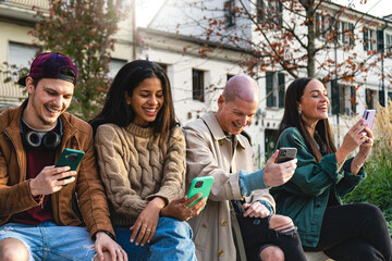Group of multiracial friends using mobile phone outdoors at campus college yard, Happy young trendy...