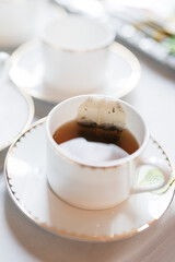 Teacup and saucer with teabag at a party
