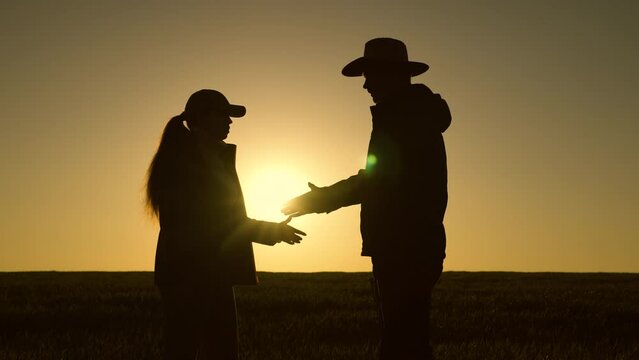 Agriculture. farming concept. field wheat agronomist farmer working in tablet at sunset. teamwork. business partner. handshake in wheat field. silhouette working people field.farmer tablet silhouette