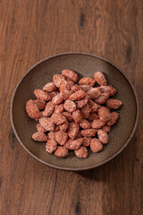 vista cenital de vasija con garrapiñadas dulces sobre fondo de madera