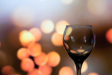 Horizontal close up of glass cup of wine empty with copy space in lights bokeh background