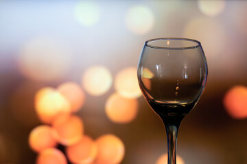 Horizontal close up of glass cup of wine empty with copy space in lights bokeh background