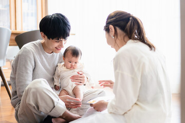 赤ちゃんに絵本の読み聞かせをするファミリー