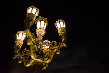 Fototapeta na wymiar Ancient magical lamp post shining on the dark night
