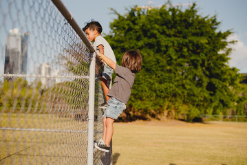 Kids playing and climbing a fence