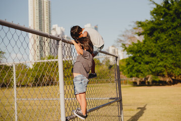 Kids playing and climbing a fence
