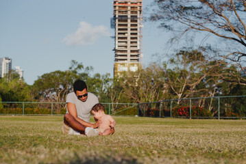 "Joyful Uncle Bonds with Baby Boy in a Relaxed Park Setting"

