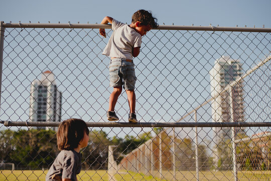 Kids playing and climbing a fence