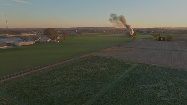 Aerial View of Farmlands at Sunrise, Farmlands, With a Steam Train Approaching Blowing Lots of Smoke
