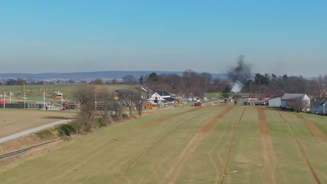 Aerial View of a Steam Passenger Train Approaching, Blowing Smoke, while Traveling Thru the Country