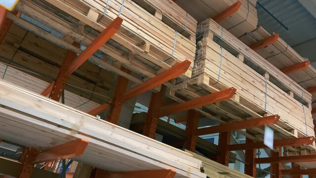 Stacks of new boards lie on the shelves of the woodworking plant's warehouse.