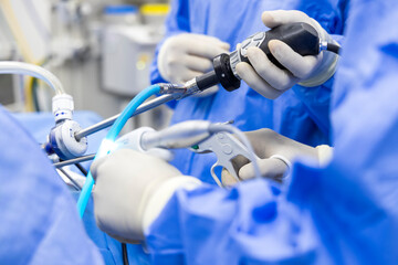A team of doctor or surgeon did surgery inside operating room in hospital.People holding medical equipment or surgical tool in keyhole endoscopic surgery.Minimal invasive joint arthroscopic procedure. - obrazy, fototapety, plakaty