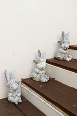 Three of Adorable Easter Bunny Figurines on Wooden Steps