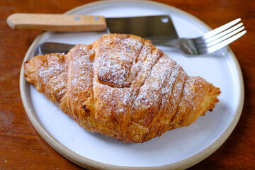 one croissants on white plate