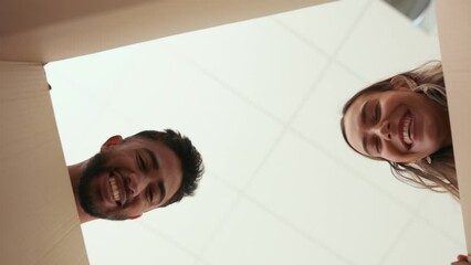 Below, moving house and packaging with a couple opening a box together in their new home. Unpacking, cardboard or relocating with a man and woman homeowner bonding while happy in their apartment