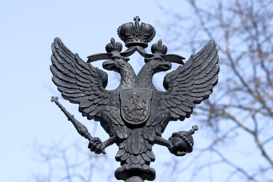 KRONSTADT, RUSSIA - MARCH 13, 2023: The old skullpture of the two-headed eagle is the coat of arms of the Russian Empire. Fragment of the design of the gate of the Summer Garden
