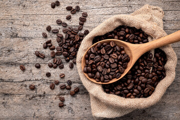 Background of dark roasted coffee beans with scoops setup on wooden background with copy space. - 582360436